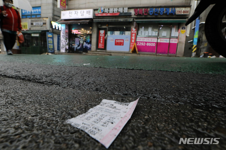 [서울=뉴시스] 백동현 기자 = 서울 시내 한 복권 판매점 인근에 로또가 떨어져 있다.  2023.03.12. livertrent@newsis.com