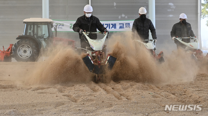 [화성=뉴시스] 김종택 기자 = 영농철을 앞둔 13일 경기도 화성시 기산동 경기도농업기술원에서 관계자들이 관리기로 경운작업을 하는 등 농기계 점검을 하고 있다. 2023.03.13. jtk@newsis.com