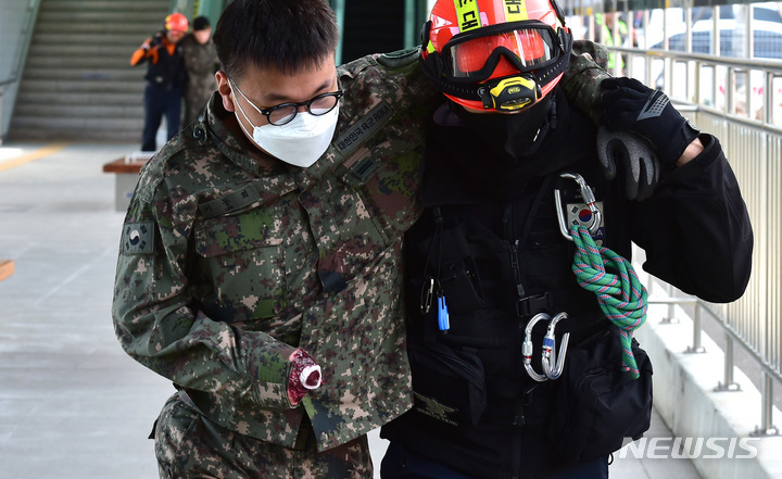 [대구=뉴시스] 이무열 기자 = 14일 오후 대구 서구 이현동 서대구역에서 열린 '민·관·군·경·소방 통합 피해복구훈련'에서 소방대원이 부상 입은 군인을 응급처치 후 호송하고 있다. 이날 훈련은 유사시 다중이용시설 피해복구를 목표로 50사단 군병력 70여 명, 경찰·소방·지자체 30여 명 등이 참여했다. 2023.03.14. lmy@newsis.com