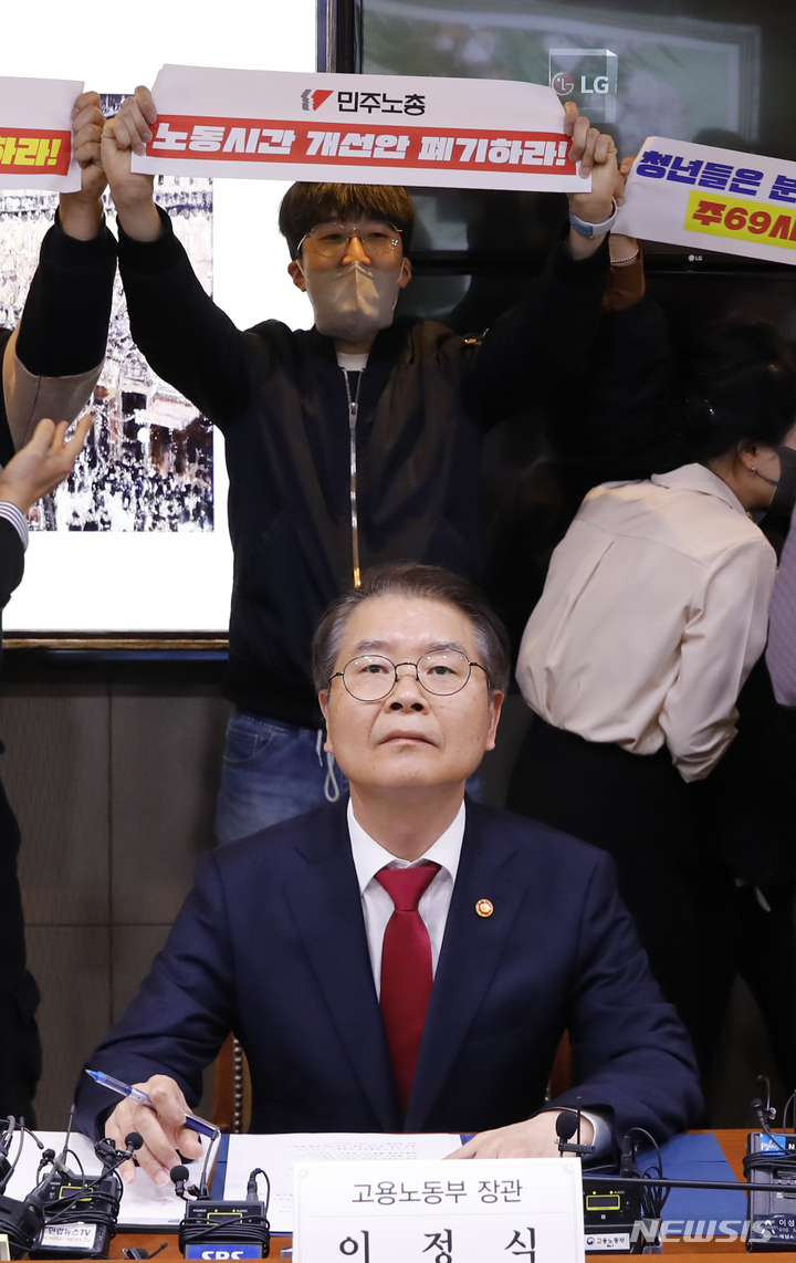 [서울=뉴시스] 고승민 기자 = 민주노총 회원들이 15일 서울지방고용노동청에서 열린 근로시간 기록, 관리 우수사업장 노사간담회장에 들어와 이정식 고용노동부 장관 뒤에서 피켓시위를 하고 있다. 2023.03.15. kkssmm99@newsis.com