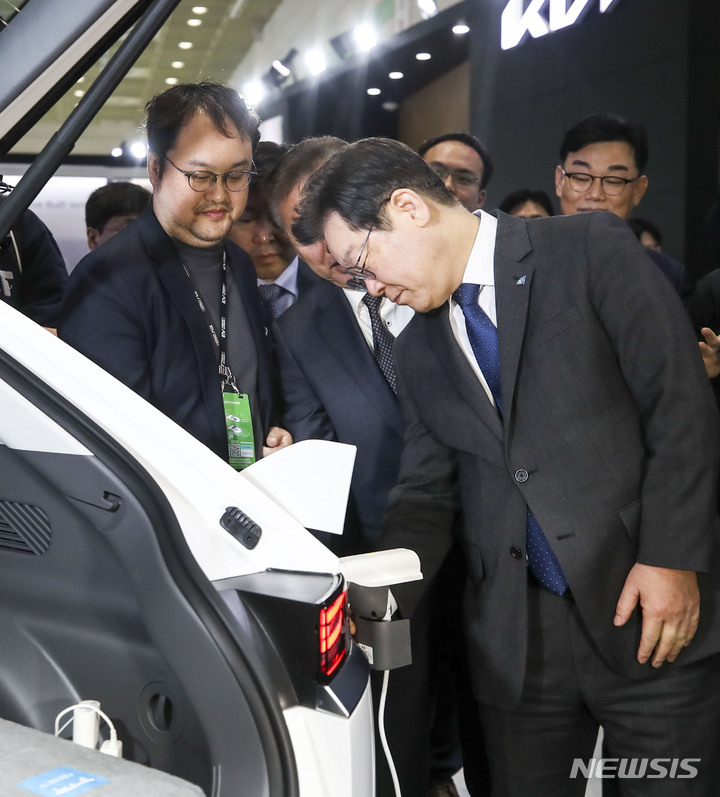 [서울=뉴시스] 정병혁 기자 = 이재명 대통령이 더불어민주당 대표를 맡고 있던 2023년 3월16일 오전 서울 강남구 코엑스에서 열린 EV트렌드코리아 2023에서 전기차 전기로 다른 전자기기를 사용할 수 있는 인버터 기술을 살펴보고 있다. 2023.03.16. jhope@newsis.com
