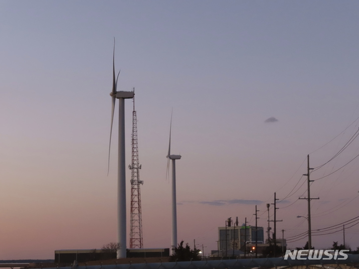 [ 아틀랜틱시티( 미 뉴저지주)=AP/뉴시스] 뉴저지주 아틀랜틱시티 해안선 부근의 풍력단지 뒤로 해가 지는 장면. ( 2022년 2월. AP자료사진) 