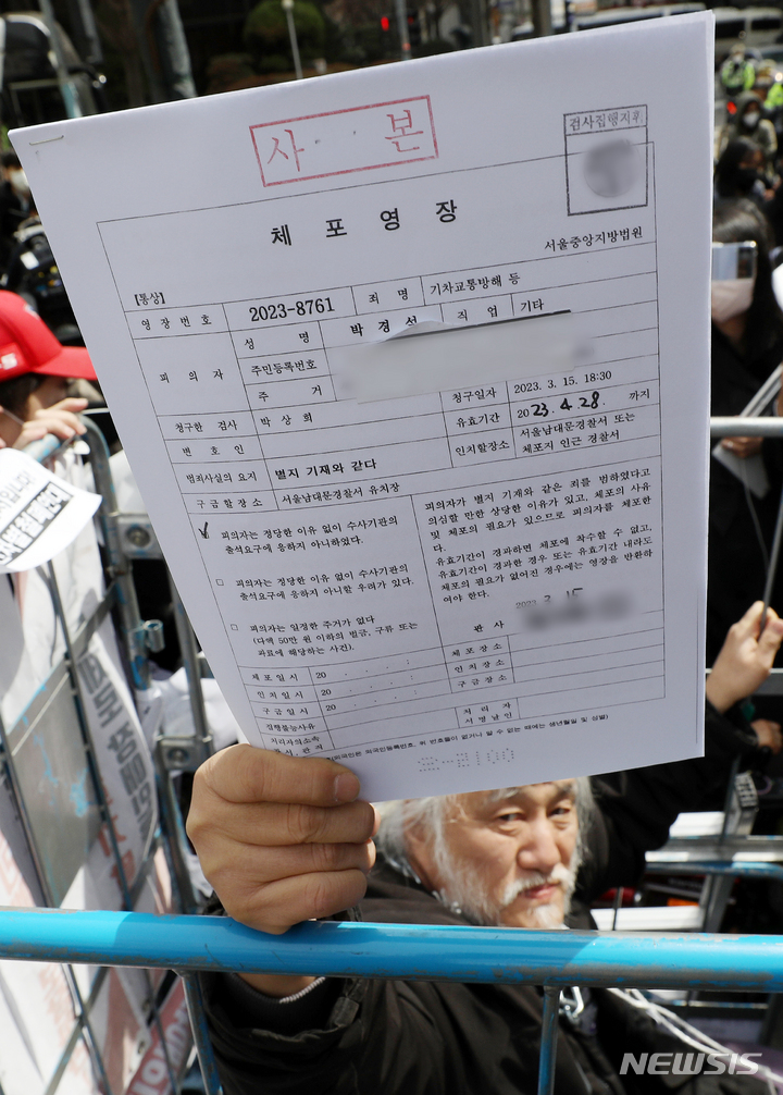 [서울=뉴시스] 조성우 기자 = 박경석 전국장애인차별철폐연대(전장연) 공동상임대표가 17일 오전 서울 종로구 서울경찰청 민원실 앞에서 경찰이 제시한 체포영장을 보여주고 있다. 2023.03.17. xconfind@newsis.com