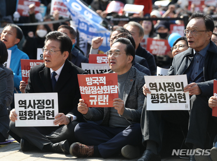 [서울=뉴시스] 김진아 기자 = 더불어민주당 이재명(왼쪽부터) 대표와 박홍근 원내대표 이해찬 상임고문이 18일 오후 서울 중구 서울광장에서 열린 '대일 굴욕외교 규탄 범국민대회'에 참석해 구호를 외치고 있다. 2023.03.18. bluesoda@newsis.com