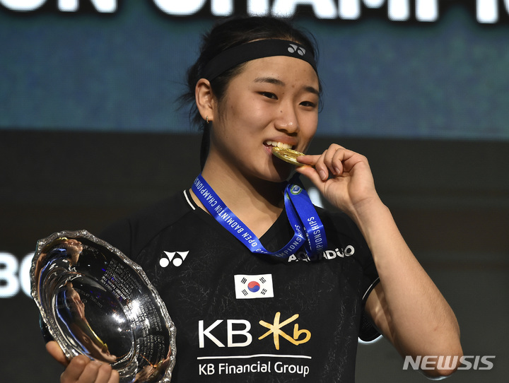 [버밍엄=AP/뉴시스] 안세영(2위)이 19일(현지시간) 영국 버밍엄에서 열린 세계배드민턴연맹(BWF) 요넥스 전영오픈 여자 단식 정상에 올라 금메달을 깨물며 포즈를 취하고 있다. 상대 전적 2승8패로 열세인 안세영은 천위페이(4위·중국)를 2-1(21-17 10-21 21-19)로 꺾고 방수현 이후 27년 만에 이 대회 우승을 차지했다. 2023.03.20.