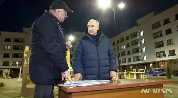 [마리우폴=AP/뉴시스] 19일(현지시간) 크렘린궁이 공개한 영상 사진에서 블라디미르 푸틴 러시아 대통령이 우크라이나 도네츠크주 마리우폴을 방문해 마라트 쿠스눌린 러시아 부총리의 말을 듣고 있다. 2023.03.20.