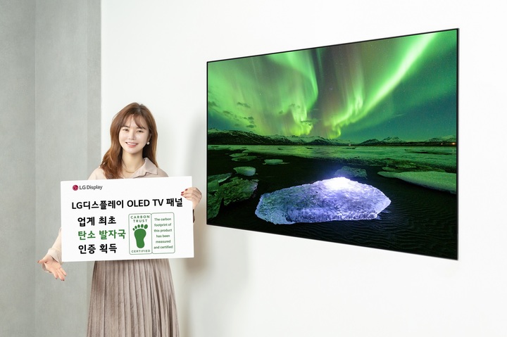 [서울=뉴시스]LG디스플레이 OLED TV 패널이 디스플레이 업계 최초로 카본 트러스트 탄소발자국 인증을 획득했다. LG디스플레이 모델이 카본 트러스트 인증서와 OLED TV 패널을 소개하고 있다. (사진 = LG디스플레이) 2023.3.19. photo@newsis.com *재판매 및 DB 금지