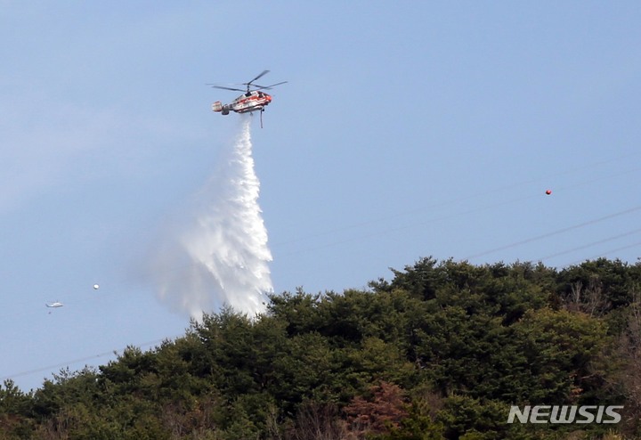 [순천=뉴시스] 이창우 기자=19일 오전 순천시 별량면 금치리 인근 야산에서 발생한 산불이 이틀째 이어지고 있는 가운데 산림청 소속 헬기가 산불 진화 작업을 벌이고 있다. 산불은 18일 21시경 발생했다. (사진=전남도 제공) 2023.03.19. photo@newsis.com *재판매 및 DB 금지