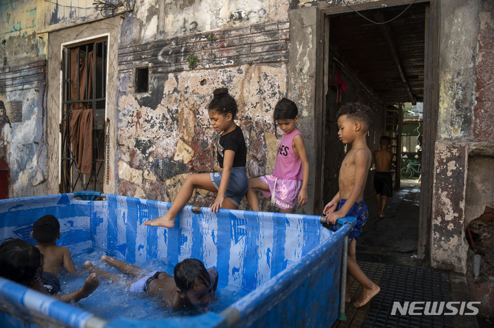 [서울=AP/뉴시스] 아르헨티나 부에노스아이레스에 거주 중인 아이들이 지난 14일(현지시간), 보도에 있는 간이 수영장에서 기록적인 폭염을 피하고 있다 2023.03.14. *재판매 및 DB 금지