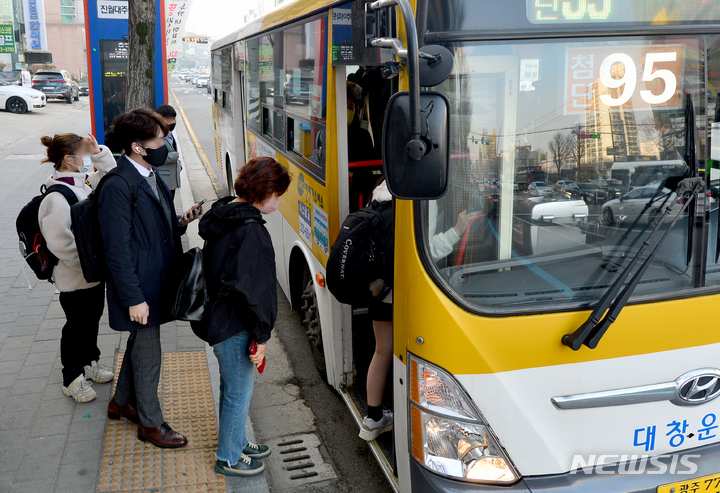 [광주=뉴시스] 김혜인 기자 = 대중교통 내 마스크 착용 의무 해제 첫날인 20일 오전 광주 남구 진월동 버스정류장에서 시민들이 마스크를 착용한 채 버스를 타고 있다. 2023.03.20. hyein0342@newsis.com