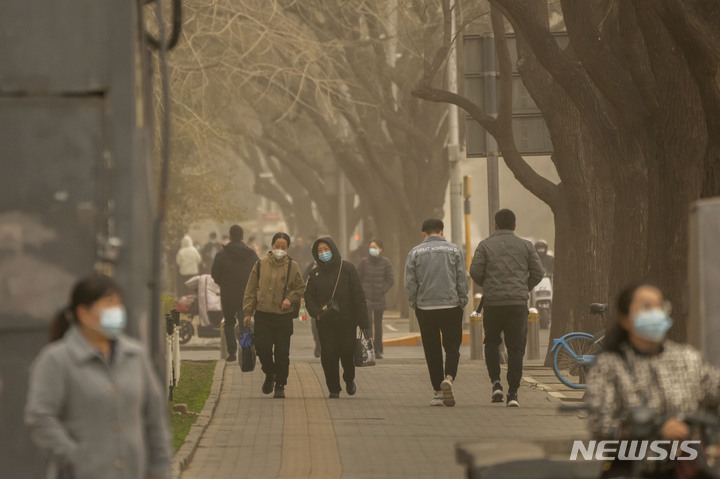 [베이징=AP/뉴시스] 지난해 3월22일 중국 베이징의 중심가에서 마스크를 쓴 시민들이 거리를 걷고 있다. 이날 아침 베이징은 황사와 모래폭풍으로 대기질 지수가 치솟았다. 2024.06.27.