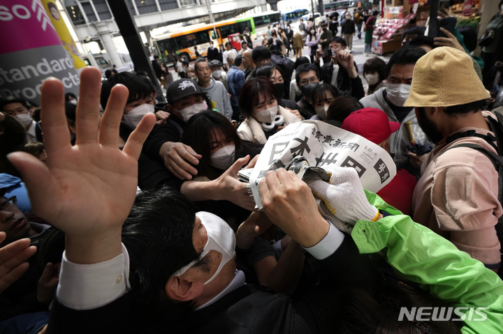 [도쿄=AP/뉴시스] 일본팀이 미국팀을 꺽고 제5회 월드베이스볼 클래식(WBC)을 제패한 뉴스를 실은 요미우리 신문의 호외가 22일 도쿄 시내에서 배포되자 행인들이 몰려 앞다퉈 받아가고 있다.  2023.03.22