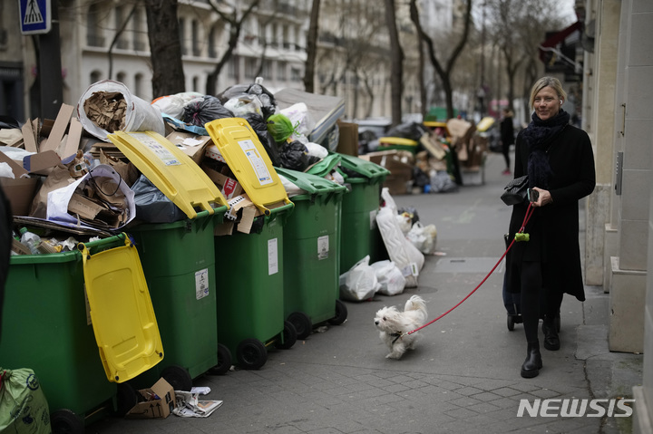 [파리=AP/뉴시스] 프랑스 정부가 1월 1일부터 음식물 쓰레기 분리배출 정책을 시행하며 현지 언론이 '분리 배출 모범 국가' 한국의 사례를 조명했다. 사진은 2023년 3월 한 시민이 쓰레기가 무분별하게 버려진 쓰레기통 옆을 지나가는 모습. (*본문과 관련 없는 사진) 2024.01.17.