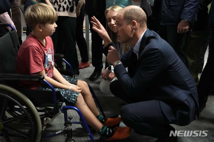 [바르샤바=AP/뉴시스] 윌리엄 영국 왕세자가 22일(현지시간) 폴란드 바르샤바에 도착한 우크라이나 난민에게 제공되는 숙박 시설을 방문해 어린 소년과 이야기를 나누고 있다. 2023.03.23.