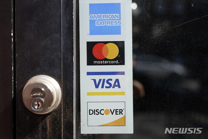 [케임브리지(미 매사추세츠주)=AP/뉴시스지난 2]021년 7월5일 미 매사추세츠주 케임브리지의 한 점포 문에 신용카드 로고가 붙어 있다. 미 연준(FRB)이 다시 금리를 인상한 가운데 미국인들의 신용카드 채무는 2022년 4분기 미국의 신용카드 채무는 9860억 달러(1263조660억원)로 종전 최고치 9270억 달러(1187조9505억원)를 넘어섰으며, 매달 빚을 떠안는 사람들이 늘고 있다. 2023.3.23.