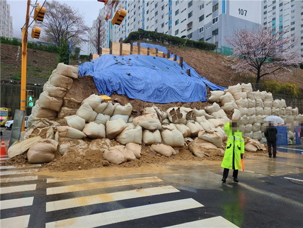 [부산=뉴시스] 23일 오전 부산 북구의 한 아파트 공사현장에서 옹벽 철거 후 설치된 방호벽이 비로 인해 무너졌다. (사진=부산경찰청 제공) *재판매 및 DB 금지