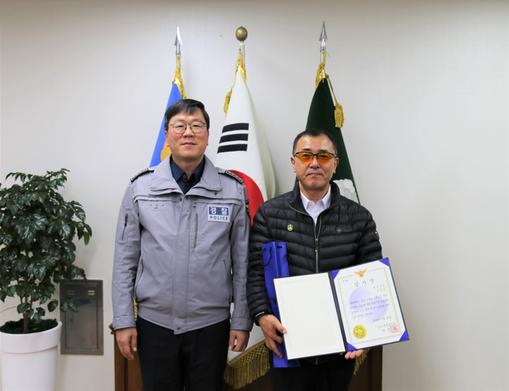 [서울=뉴시스] 임철휘 기자 = 이진수 서울 노원경찰서장이 일본인 관광객의 분실물을 적극적으로 신고한 이성문(55)씨에게 감사장을 수요하고 있다. (사진=서울노원경찰서 제공) 2023.03.23. fe@newsis.com *재판매 및 DB 금지