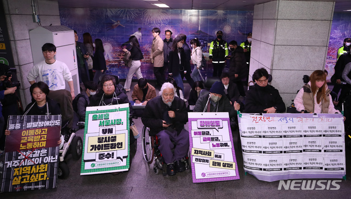 [서울=뉴시스] 김진아 기자 = 전국장애인차별철폐연대(전장연)가 23일 서울 지하철 1호선 시청역에서 오세훈 서울시장 대화 촉구 출근길 지하철 탑승선전전을 진행하자, 시민들이 경찰과 지하철 보안관의 안내에 따라 이동하고 있다. 2023.03.23. bluesoda@newsis.com