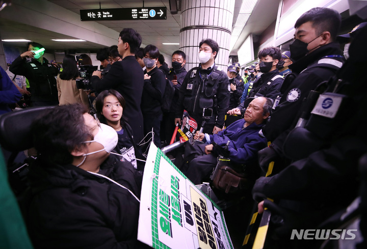 [서울=뉴시스] 김진아 기자 = 전국장애인차별철폐연대(전장연)가 지난달 23일 서울 지하철 1호선 시청역에서 오세훈 서울시장 대화 촉구 출근길 지하철 탑승선전전을 한 뒤 지하철 탑승을 시도했지만, 이를 저지하는 경찰과 지하철 보안관에 막혀 대치하고 있다. 2023.03.23. bluesoda@newsis.com