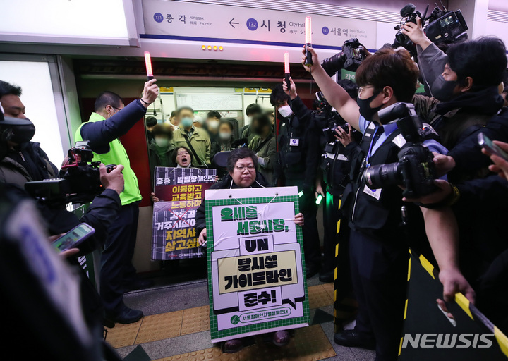 [서울=뉴시스] 김진아 기자 = 전국장애인차별철폐연대(전장연)가 23일 서울 지하철 1호선 시청역에서 오세훈 서울시장 대화 촉구 출근길 지하철 탑승선전전에 참여하기 위해 지하철에서 내리고 있다. 2023.03.23. bluesoda@newsis.com