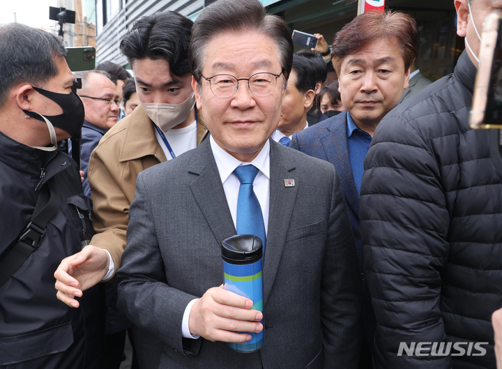 [서울=뉴시스] 권창회 기자 = 이재명 더불어민주당 대표가 23일 오전 서울 성북구 장위2동 카페에서 커피를 구매한 뒤 주민센터에서 열리는 지역사랑상품권법 관련 간담회 참석을 위해 이동하고 있다.(공동취재사진) 2023.03.23.photo@newsis.com