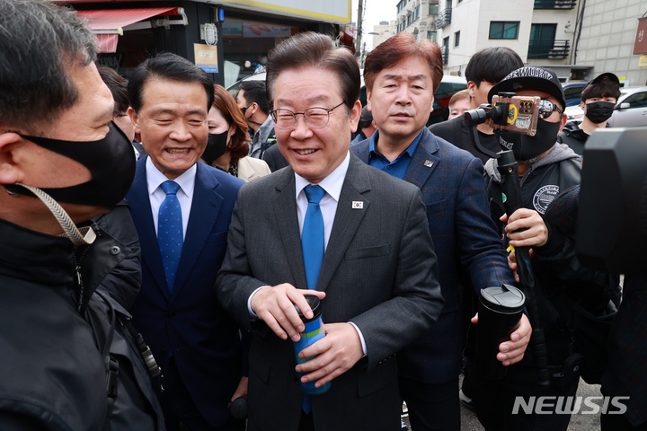 [서울=뉴시스] 권창회 기자 = 이재명 더불어민주당 대표가 23일 오전 서울 성북구 장위2동 카페에서 커피를 구매한 뒤 주민센터에서 열리는 지역사랑상품권법 관련 간담회 참석을 위해 이동하고 있다.(공동취재사진) 2023.03.23.photo@newsis.com
