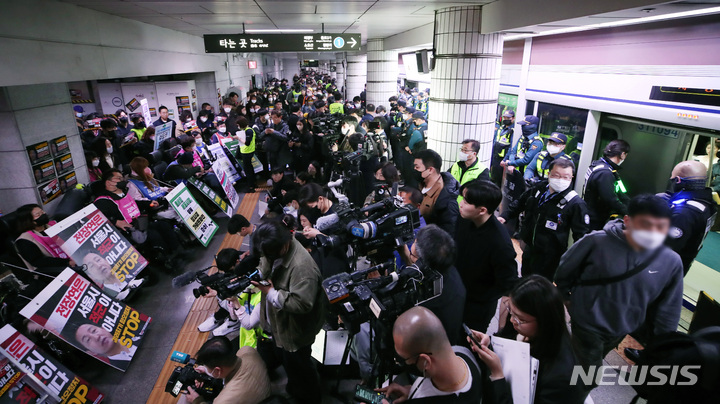 [서울=뉴시스] 김진아 기자 = 전국장애인차별철폐연대 회원들이 23일 서울 지하철 1호선 시청역에서 서울420장애인차별철폐연대 투쟁 선포 결의대회 진행하자, 시민들이 경찰과 지하철 보안관의 안내에 따라 이동하고 있다. 2023.03.23. bluesoda@newsis.com