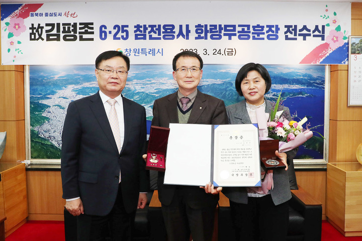 [창원=뉴시스] 강경국 기자 = 홍남표 경남 창원시장(왼쪽)이 24일 시청 접견실에서 6·25 전쟁에 참전해 공적을 세운 고(故) 김평존 일병의 유가족인 조카 김두열씨에게 화랑무공훈장을 전수하고 있다. (사진=창원시청 제공). 2023.03.24. photo@newsis.com *재판매 및 DB 금지