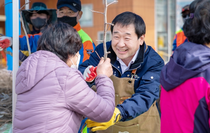 [증평=뉴시스] 강신욱 기자 = 이재영 충북 증평군수가 24일 증평군립도서관 앞에서 열린 내 나무 갖기 캠페인에서 군민들에게 유실수 묘목을 나눠주고 있다. (사진=증평군 제공) 2023.03.24. photo@newsis.com *재판매 및 DB 금지