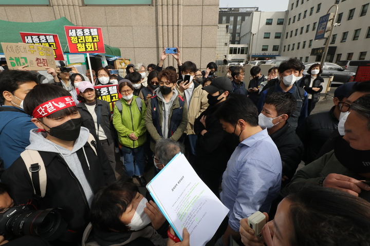 [서울=뉴시스] 김금보 기자 = 24일 오전 서울 중구 퇴계로 세종호텔 앞에서 중구청 직원들이 세종호텔 해고자들 농성천막 행정대집행을 통보하고 있다. 2023.03.24. kgb@newsis.com