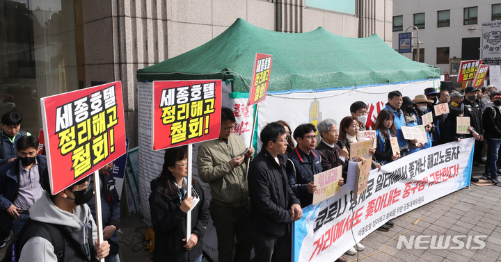 [서울=뉴시스] 김금보 기자 = 세종호텔 정리해고 철회를 위한 공동대책위원회 활동가들이 24일 오전 서울 중구 세종호텔 앞 천막농성장에서 기자회견을 열고 중구청의 민주노총 서비스연맹 세종호텔지부 천막농성장 철거 행정대집행 시도를 규탄하고 있다. 2023.03.24. kgb@newsis.com