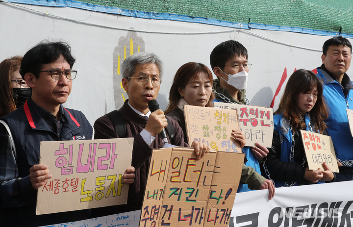 [서울=뉴시스] 김금보 기자 = 세종호텔 정리해고 철회를 위한 공동대책위원회 활동가들이 24일 오전 서울 중구 세종호텔 앞 천막농성장에서 기자회견을 열고 중구청의 민주노총 서비스연맹 세종호텔지부 천막농성장 철거 행정대집행 시도를 규탄하고 있다. 2023.03.24. kgb@newsis.com