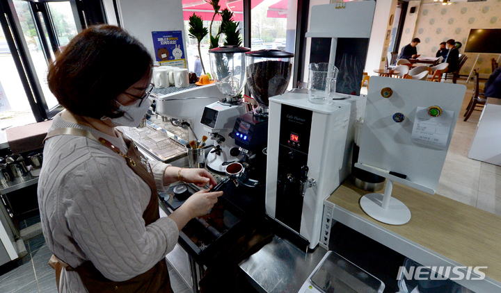 [광주=뉴시스] 김혜인 기자 = 24일 오전 광주 서구 농성동 마을협동조합이 운영하는 '상록벚꽃마을 카페'에서 주민이 음료를 만들고있다.&nbsp; 2023.03.24.hyein0342@newsis.com