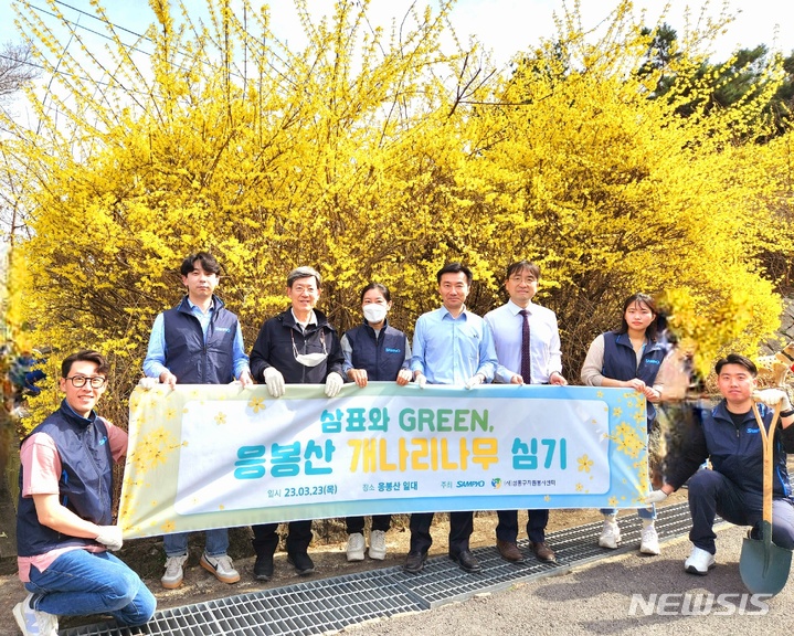 [서울=뉴시스] 삼표그룹 임직원들이 지난 23일 성동구 주최로 열린 '2023 응봉산 개나리 축제'에서 개나리 묘목을 심는 봉사활동을 진행한 후 기념사진을 촬영하고 있다. (제공 = 삼표그룹)