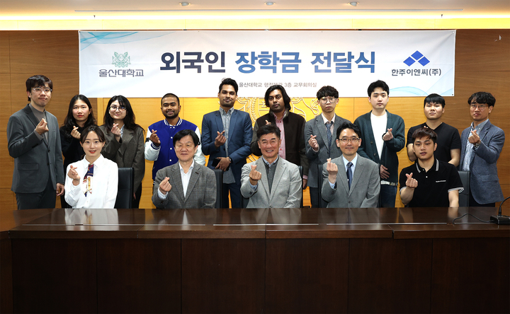 [울산=뉴시스] 구미현 기자 = 울산대학교 외국인 학생들이 27일 울산대 행정본관 3층 교무회의실에서 강문기 한주이엔씨㈜ 대표(앞줄 왼쪽에서 세 번째)가 주는 장학금을 받은 뒤 신영한 울산대 국제교류처장(네 번째) 등과 손하트 포즈를 취하고 있다. 2023.03.27. (사진=울산대 제공) *재판매 및 DB 금지