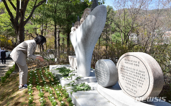 [대구=뉴시스] 이무열 기자 = 개구리소년 32주기 추모제가 열린 27일 오후 대구 달서구 와룡산 선원공원 개구리소년 추모 및 어린이 안전 기원비 앞에서 참석자가 헌화하고 있다. 2023.03.27. lmy@newsis.com