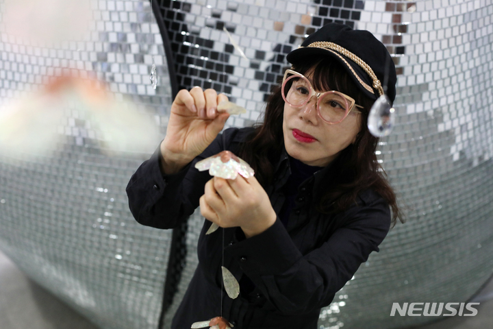 [서울=뉴시스] 박진희 기자 = 환경과 인간의 문제를 탐구해온 설치미술가 심영철(수원대 교수) 작가가 27일 서울 종로구 선화랑에서 개인전 'Dancing Garden' 전시 개막을 앞두고 인터렉티브 작품인 '꽃비 정원' 설치하고 있다. 2023.03.27. pak7130@newsis.com