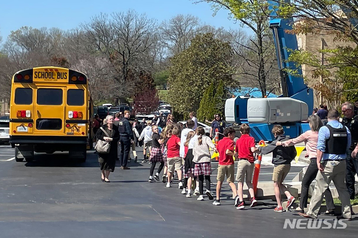 [내슈빌=AP/뉴시스] 27일(현지시간) 미 테네시주 내슈빌의 코브넌트 사립 초등학교에서 총격이 발생한 후 이 학교 학생들이 손에 손잡고 부모와 만날 장소로 가기 위해 버스에 오르고 있다. 앞서 20대 트랜스젠더 여성이 이 학교에서 총기를 난사해 학생 3명과 성인 3명이 숨졌고 이 여성은 출동 경찰에 사살됐다. 이 학교 졸업생으로 알려진 용의자는 범행 전 자세한 현장 조사까지 한 것으로 밝혀져 충격을 주고 있다. 2023.03.28.