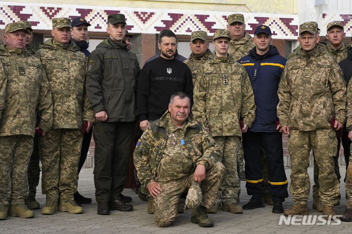 [오흐티르카=AP/뉴시스] 볼로디미르 젤렌스키(가운데) 우크라이나 대통령이 28일(현지시간) 수미주 오흐티르카를 방문해 군인, 경찰관들을 격려하고 함께 기념 촬영하고 있다. 젤렌스키 대통령은 이날 수미주 오흐티르카와 트로스티아네츠를 찾아 우크라이나군과 시민을 격려했다. 2023.03.29.