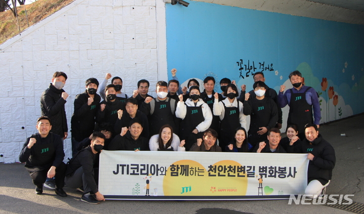 [서울=뉴시스]지난 13일 JTI코리아 천안아산 지점 임직원들이 천안시 신방동에 위치한 천안천변길 지하차도에서 벽화 봉사를 진행했다.(사진=JTI코리아 제공)