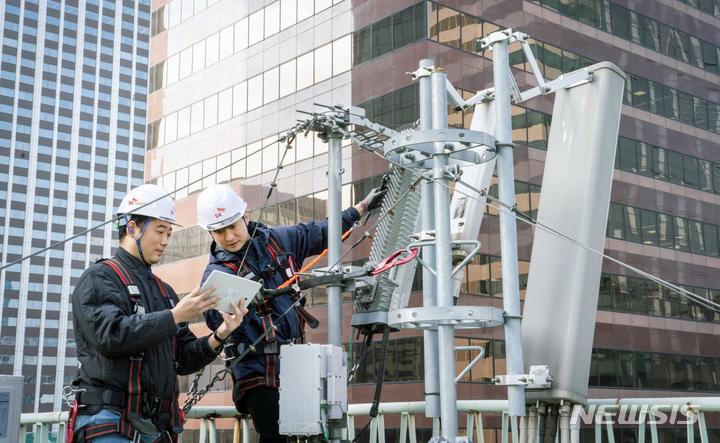 [서울=뉴시스]SK텔레콤은 무선 네트워크 품질 관리 AI 솔루션 A-STAR를 개발해 자사의 전국 기지국에 적용했다고 28일 밝혔다. 사진은 SK텔레콤과 SK오앤에스 직원이 A-STAR를 통해 네트워크 품질을 점검하는 모습. (사진=SK텔레콤 제공)