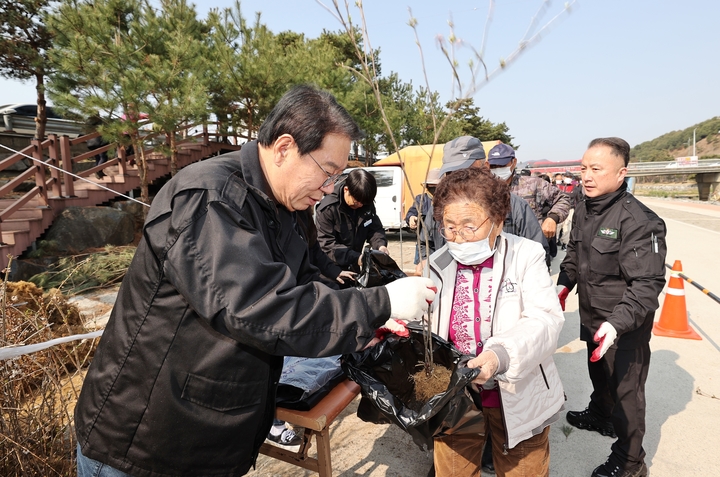 [괴산=뉴시스] 강신욱 기자 = 송인헌 충북 괴산군수가 78회 식목일을 기념해 28일 괴산읍 동진천 하상주차장에서 주민들에게 나무를 나눠주고 있다. (사진=괴산군 제공) 2023.03.28. photo@newsis.com *재판매 및 DB 금지