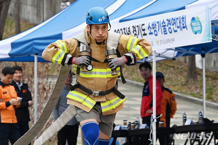 [용인=뉴시스] 김종택 기자 = 28일 경기도 용인시 처인구 경기도 소방학교에서 열린 '2023년 경기도 소방기술 경연대회'에 출전한 소방관이 소방호스를 끌고 힘차게 달리고 있다. 2023.03.28. jtk@newsis.com