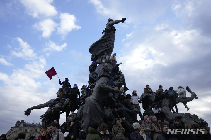 [파리=AP/뉴시스] 28일(현지시간) 프랑스 파리에서 연금 개혁 반대 시위대가 나시옹 광장의 동상에 올라가 있다. 프랑스 전역에서 에마뉘엘 마크롱 정부의 연금 개혁에 반대하는 10차 시위와 파업이 이어졌다. 마크롱 대통령은 인기를 잃더라도 국익을 위해 연금 개혁을 흔들림 없이 추진하겠다고 밝혔다. 2023.03.29.