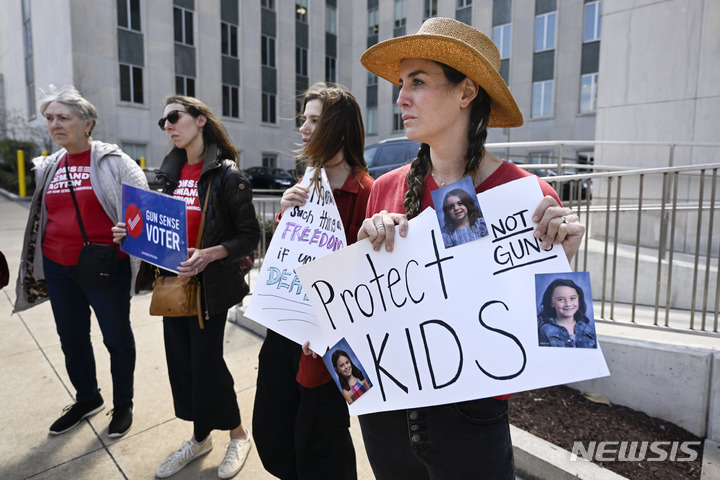 [내슈빌=AP/뉴시스] 28일(현지시간) 미 테네시주 내슈빌 의회 앞에서 딸의 사진이 붙은 손팻말을 든 여성이 다른 운동가들과 함께 총기 규제를 촉구하고 있다. (기사 내용과 관련 없음) 2023.03.28.