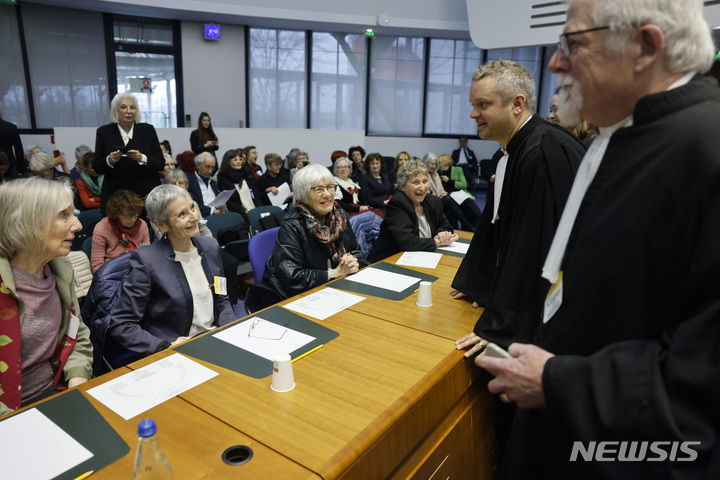 [스트라스부르(프랑스)=AP/뉴시스]연금을 받은 스위스 할머니들의 단체 '기후보호를 위한 노인 여성'의 변호사 리처드 할리(오른쪽)가 29일 프랑스 스트라스부르의 유럽인권재판소(ECHR)에서 열린 기후변화가 인권에 미치는 영향에 대한 첫 심리에서 이 단체의 회원 할머니들과 이야기하고 있다. 할머니들이 기후변화에 대해 더 강력한 조치를 취하지 않음으로써 그들의 생명과 건강에 대한 권리를 침해했다며 스위스 정부를 ECHR에 제소한 소송의 첫 심리가 이날 ECHR에서 열렸다. 2023.3.29.·