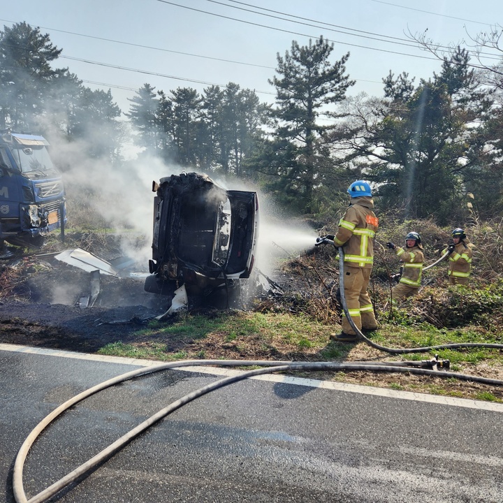 [제주=뉴시스] 오영재 기자 = 28일 오후 제주 애월읍의 한 도로에서 전도된 BMW 렌터카에 화재가 발생해 소방당국이 진화에 나서고 있다. (사진=제주서부소방서 제공) 2023.03.29. photo@newsis.com *재판매 및 DB 금지