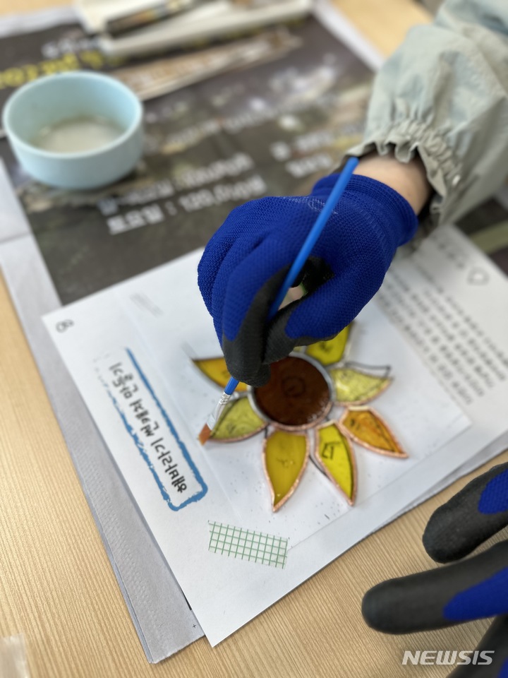 [창원=뉴시스] 홍정명 기자=29일 공예체험 프로그램에 참여한 경남교육청 본청 직원이 '해바라기 선캐처(suncatcher)'를 만들고 있다.(사진=경남교육청 제공) 2023.03.29. photo@newsis.com