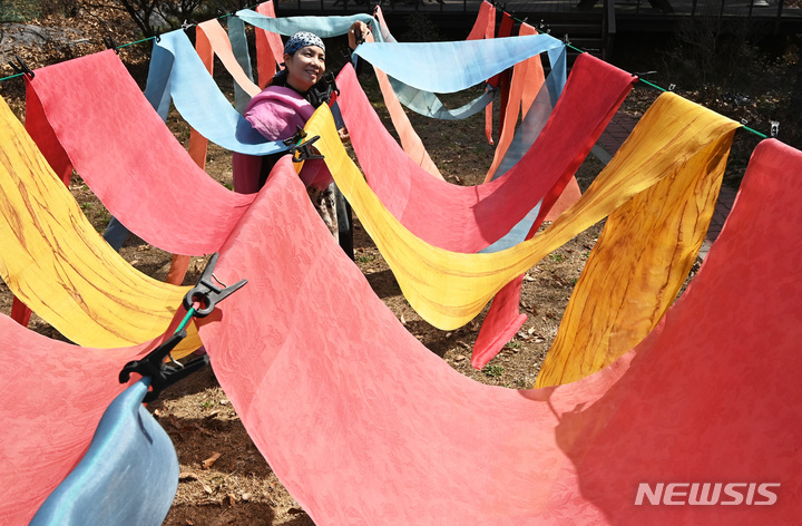 [이천=뉴시스] 김종택 기자 = 봄기운이 완연한 29일 경기도 이천시 율면 부래미마을 남해인 자연염색 공방에서 천연염색 관계자가 겨우내 물들였던 원단을 햇볕에 말리고 있다. 2023.03.29. jtk@newsis.com
