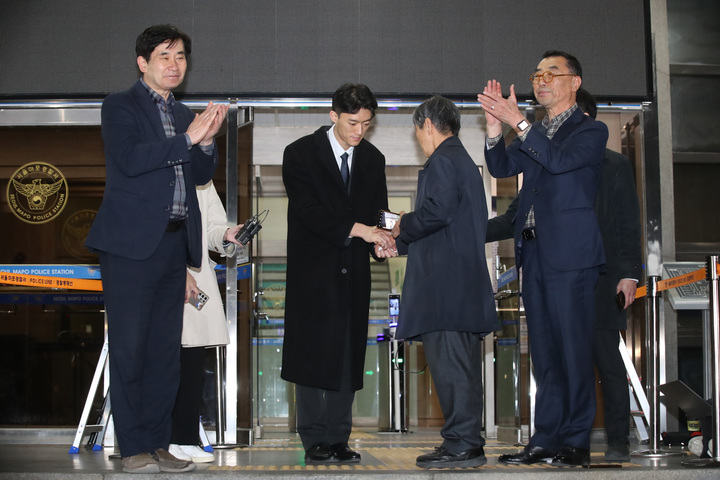 [서울=뉴시스] 조수정 기자 = 마약을 투약한 혐의로 경찰 조사를 마친 고(故) 전두환 전 대통령 손자 전우원 씨가 29일 오후 석방돼 서울 마포경찰서를 나서며 5·18 유족인 고(故)전태일 열사 동생 전태삼(오른쪽 앞) 씨, 이남(가운데 오른쪽 악수하는 이) 5·18 민주화운동부상자회 서울지부장, 임장철(왼쪽 앞) 5·18민주화운동공로자회 서울지부장과 대화하고 있다. 2023.03.29.chocrystal@newsis.com